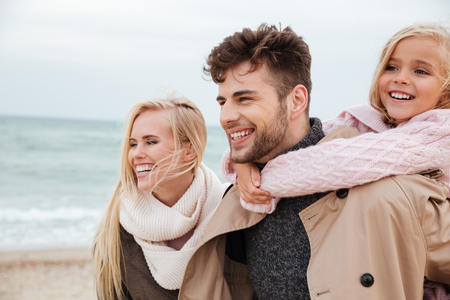 Portrait of a happy family with a little daughter having fun at the beach togetherの写真素材