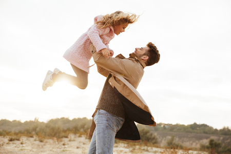 Happy father having fun with his little daughter at the beach togetherの写真素材