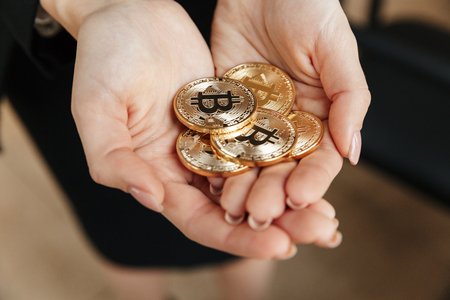 Cropped image of young business lady showing her bitcoins in hands.の写真素材