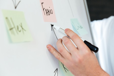 Cropped photo of businessman write something with marker on a desk.の写真素材
