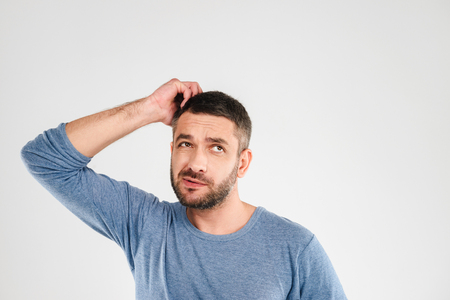 Picture of confused man standing isolated over white background wall. Looking aside.の写真素材