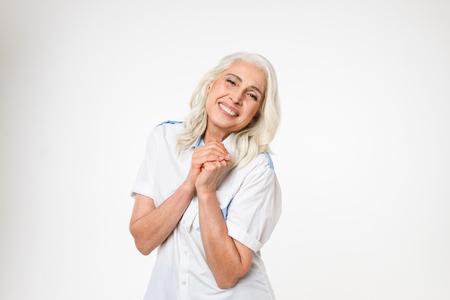 Portrait of a happy mature woman looking at camera isolated over white backgroundの写真素材