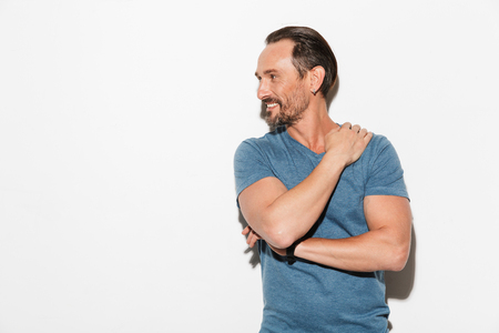 Image of happy mature man standing isolated over white background. Looking aside.の写真素材