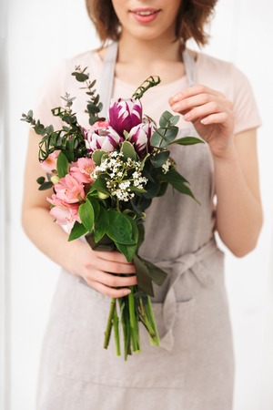 Cropped photo of florist woman standing with flowers in workshop.の写真素材