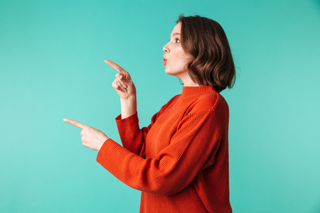 Photo of amazing lady standing isolated looking aside over blue background pointing.の写真素材