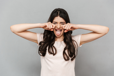 Photo of cute beautiful young lady standing isolated over grey background wall screaming.の写真素材