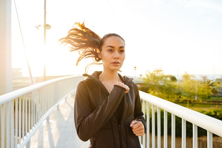 Photo of amazing beautiful young asian sports woman running outdoors.の写真素材