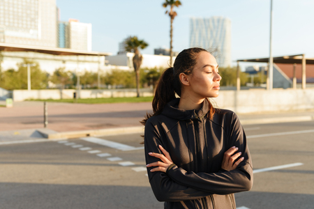 Image of attractive young asian sports woman standing outdoors.の写真素材