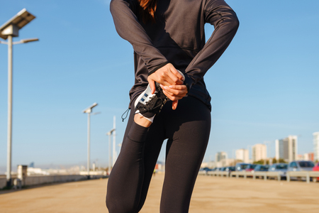 Cropped image of young sports woman make sport stretching exercises outdoors.の写真素材