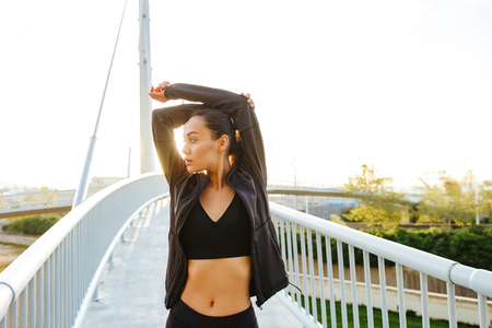 Picture of pretty beautiful young asian sports woman make stretching exercises outdoors.の写真素材