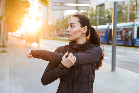 Image of gorgeous beautiful young asian sports woman make stretching exercises outdoors.の写真素材