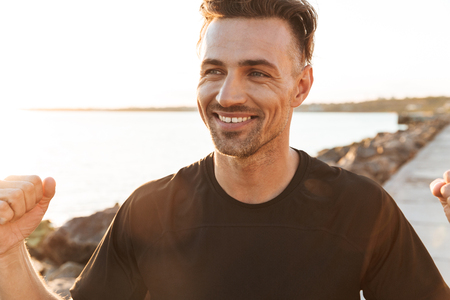 Portrait of a cheerful sportsman celebrating success outdoorsの写真素材