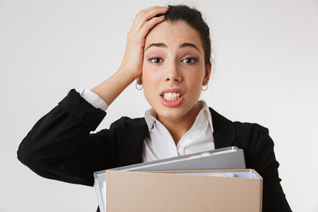 Image of young confused business woman isolated over white wall backgound looking camera holding folders.の写真素材