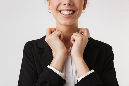 Cropped image of young business woman button his shirt isolated over white wall backgound.の写真素材
