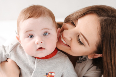 Image of happy young family. Mother having fun with her little child indoors at home.の写真素材