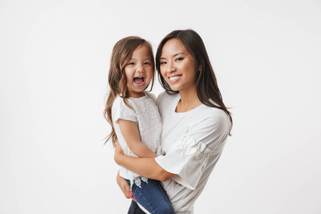 Image of happy young asian woman mother with her little girl child daughter isolated over white wall background.の写真素材
