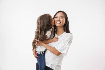 Image of happy young asian woman mother with her little girl child daughter isolated over white wall background.の写真素材
