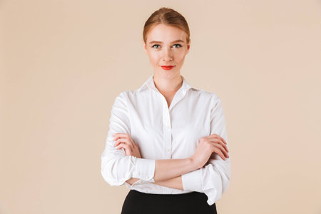 Image of gorgeous young business woman standing isolated over beige wall backgound looking camera.の写真素材