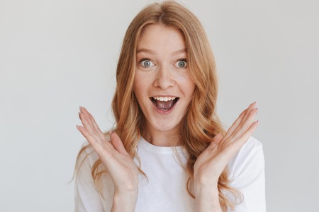 Image of young excited shocked redhead woman isolated over white wall background looking camera.の写真素材