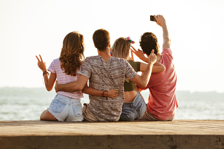 Image of group of four friends outdoors on the beach.の写真素材