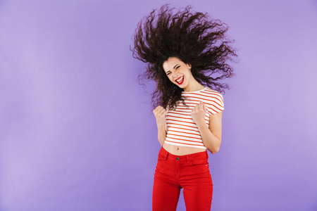 Portrait of a pretty young casual woman jumping isolated, celebratingの写真素材