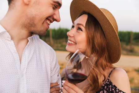Image of young cute loving couple outdoors holding glasses of wine.の写真素材