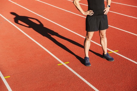 Cropped image of a sportsman finished running at the stadium