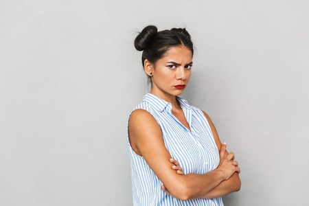 Portrait of an upset young woman isolated, standing with arms foldedの写真素材