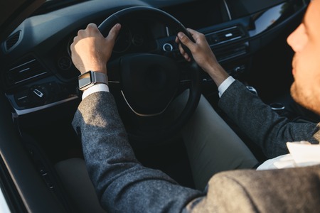 Top view of a young businessman in suit driving his car