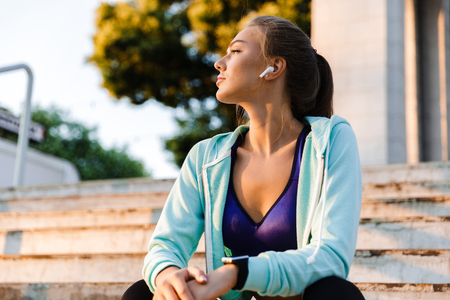 Photo of amazing young sports woman in park outdoors listening music.の写真素材