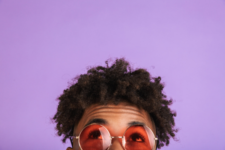 Half face portrait of a happy young afro american man in sunglasses isolated, looking upの写真素材