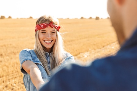 Image of amazing young cute loving couple standing on the field walking outoors.