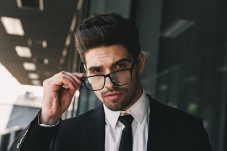 Image of handsome business man near business center looking camera wearing glasses.の写真素材