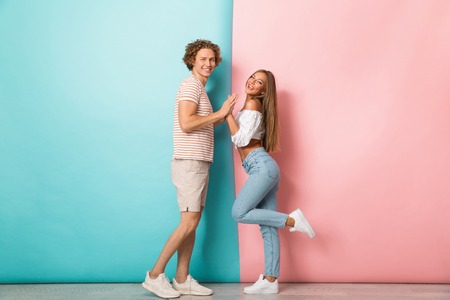 Full length portrait of a happy young couple holding handsの写真素材