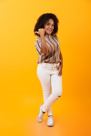 Image of amazing pretty african woman isolated over yellow background pointing.の写真素材