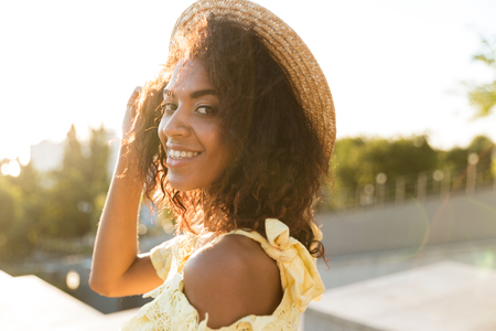 Image of african young woman walking outdoors looking camera.の写真素材