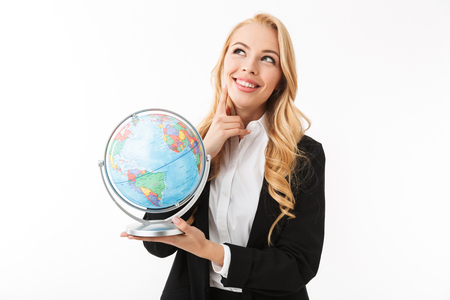 Portrait of a pretty smiling young businesswoman standing isolated over white background, holding earth globeの写真素材