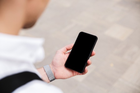 Close up of a business man holding blank screen mobile phone outdoorsの写真素材