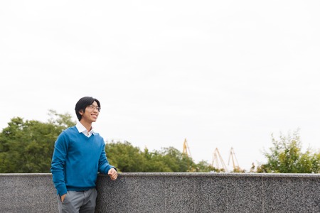 Confident asian businessman standing outdoors at the stairsの写真素材
