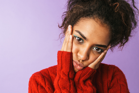 Upset young african woman wearing sweater standing isolated over violet backgroundの写真素材