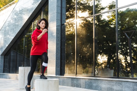 Confident fit sportswoman doing exercises outdoorsの写真素材
