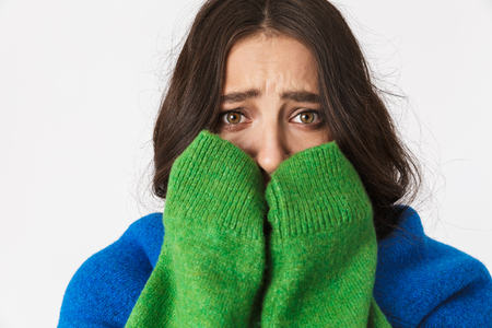 Portrait of frustrated woman 30s with dark hair in casual clothes crying while isolated over white backgroundの写真素材