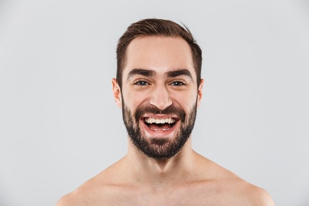 Close up of a young handsome bearded shirtless man standing isolated over white backgroundの写真素材