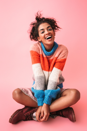 Image of a happy beautiful young african woman posing isolated over pink wall background.の写真素材