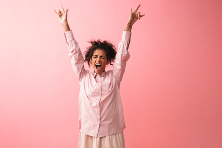 Image of a beautiful emotional young african woman posing isolated over pink wall background screaming.の写真素材