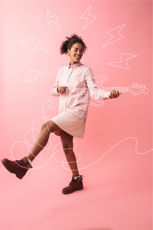 Image of a beautiful young african woman posing isolated over pink wall background screaming singing.の写真素材