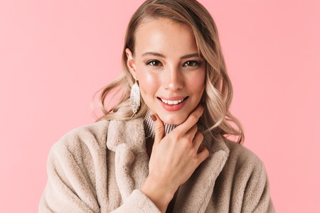 Photo of a beautiful young pretty woman posing isolated over pink wall background wearing accessories and jewelry.の写真素材