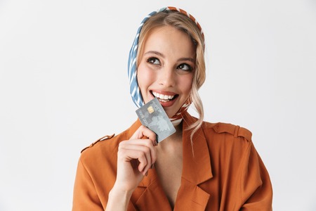 Image of a beautiful happy young woman wearing silk scarf isolated over white background holding...
