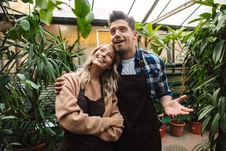 Image of two amazing gardeners posing in the nature greenhouse garden looking aside.の写真素材
