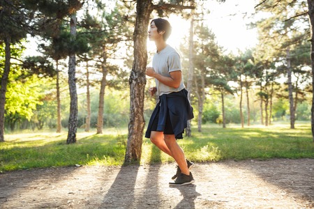 Full length of a confident asian athlete man running at the parkの写真素材